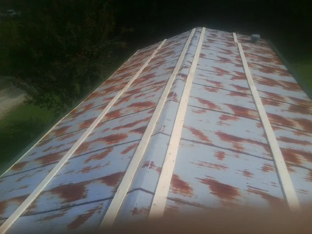 Rusted metal roof panels with new wood purlins before replacement — Storm Damage Roof Repair in Lockport by Roofing Brothers