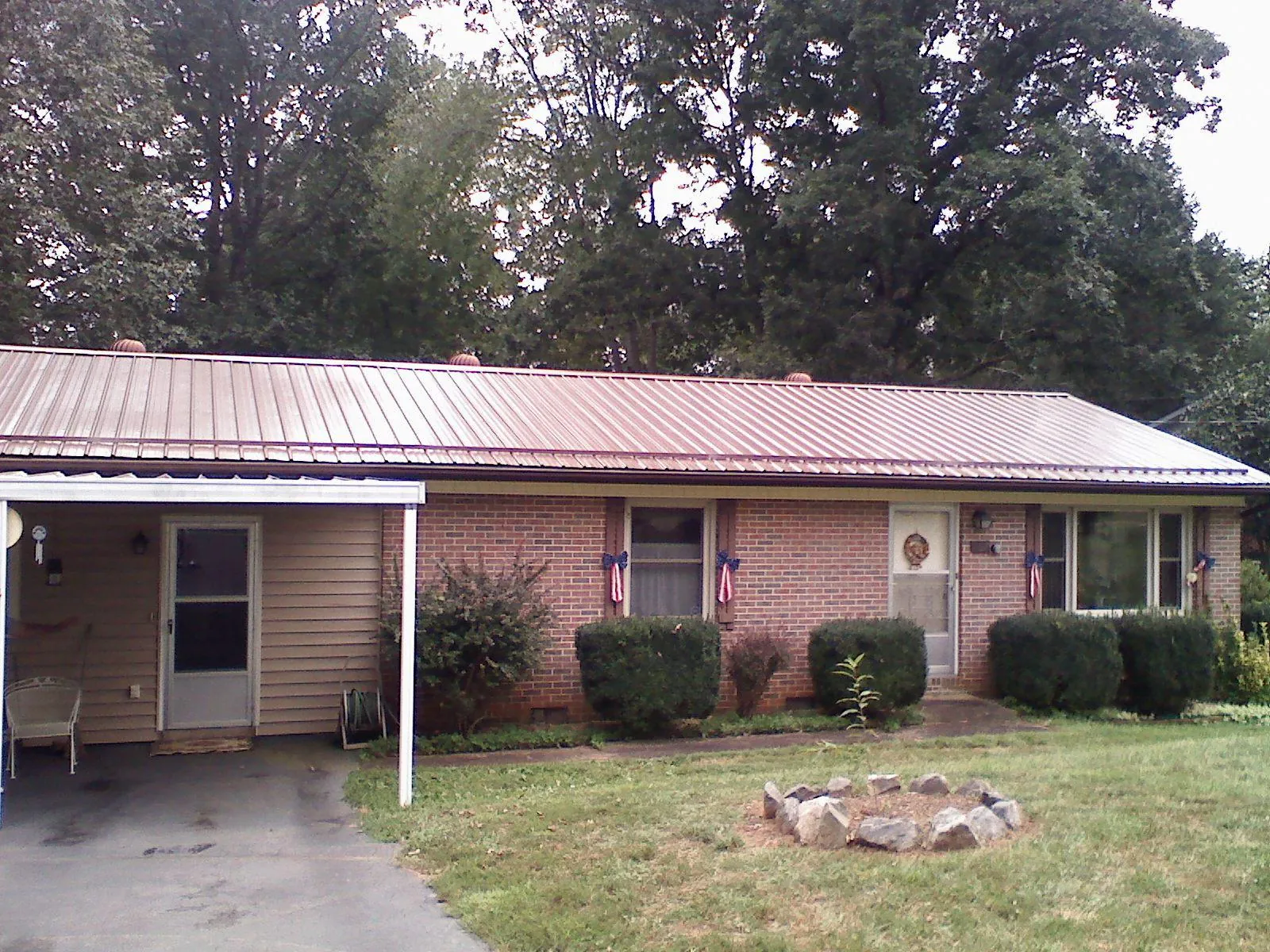 Bronze metal roof and carport on a brick ranch home — Roof Repair work by our crew in Lockport
